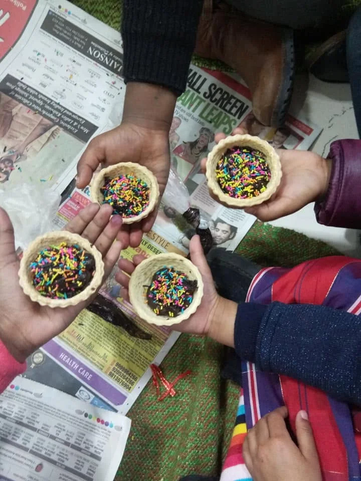 Children holding colourful handmade cupcakes