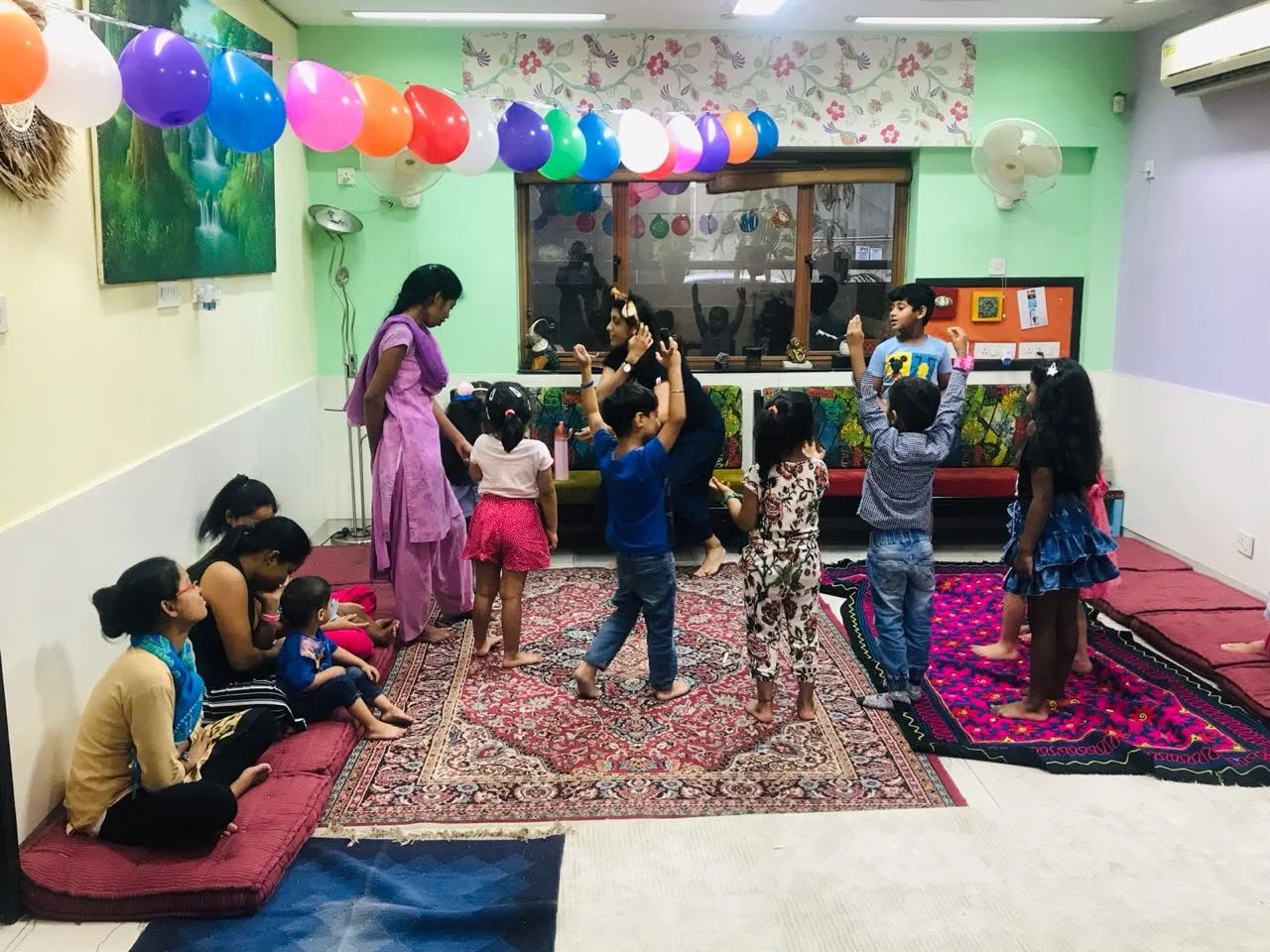 Children dancing together in the colourful Aumtara room
